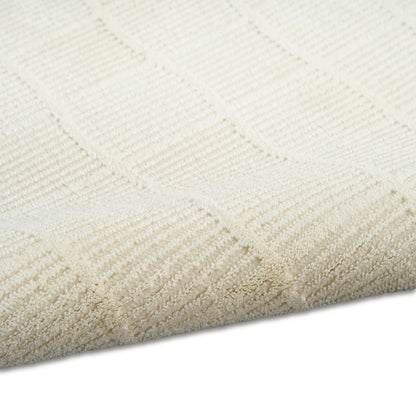 Cream rectangular rug with subtle square geometric pattern in looped pile; soft, neutral home decor.