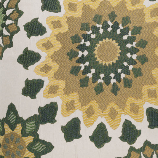Green and mustard mandala textile with zigzag radiating motifs on ivory background; decorative throw or upholstery fabric.