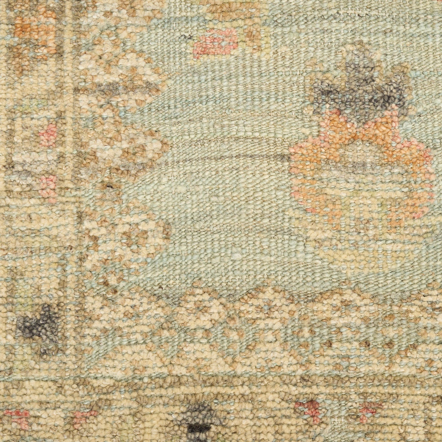 Pastel blue-green Persian-style rug with ivory and peach floral motifs; wool pile, rectangular decorative floorcovering.