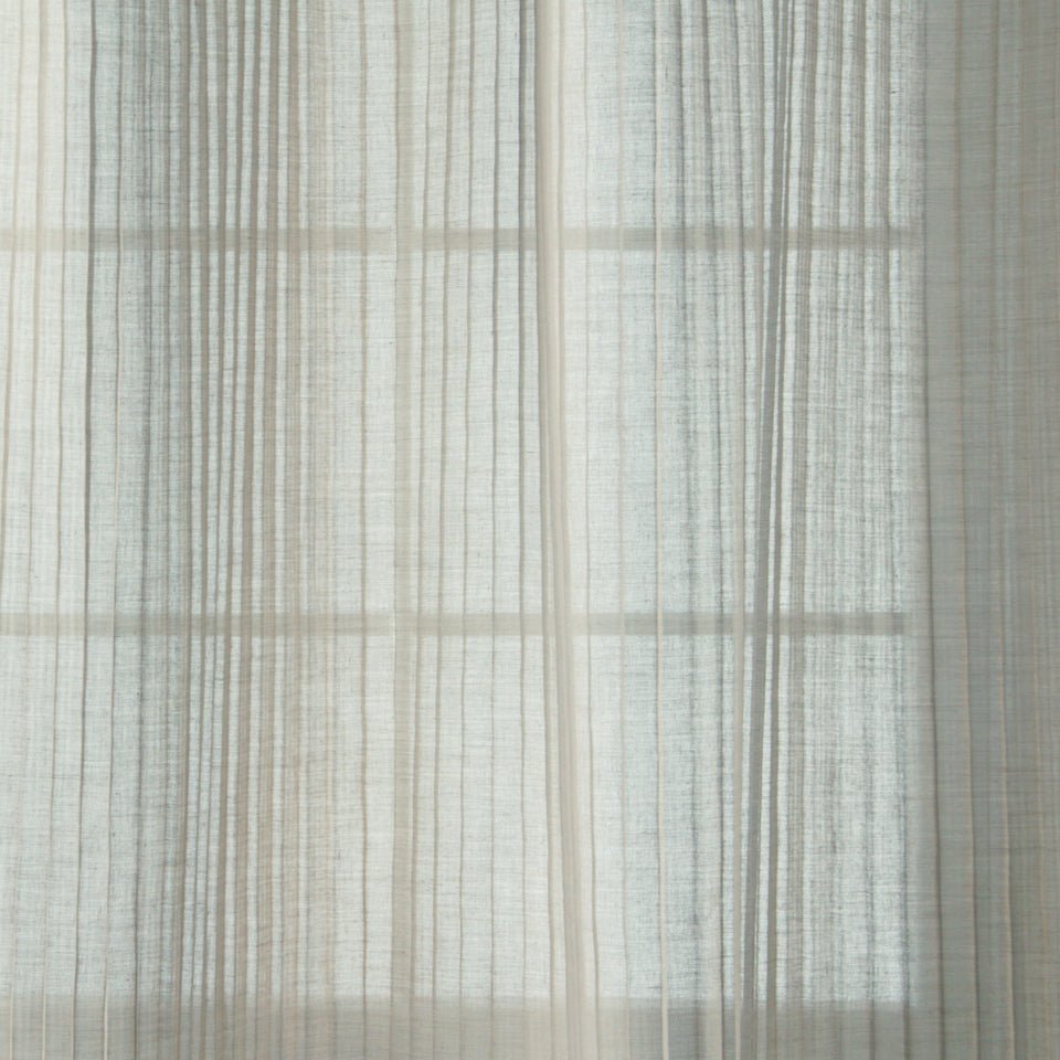 Soft sheer white curtains with pale vertical stripes, gently diffusing daylight.