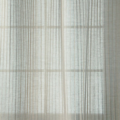 Soft sheer white curtains with pale vertical stripes, gently diffusing daylight.