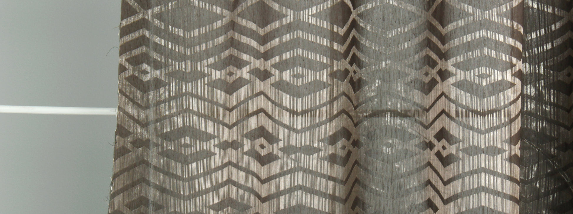 Brown and beige geometric chevron curtain panel with light-filtering fabric for windows.