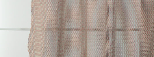 Rust-colored sheer drapery with a subtle geometric weave, light-filtering fabric hanging in front of a window.