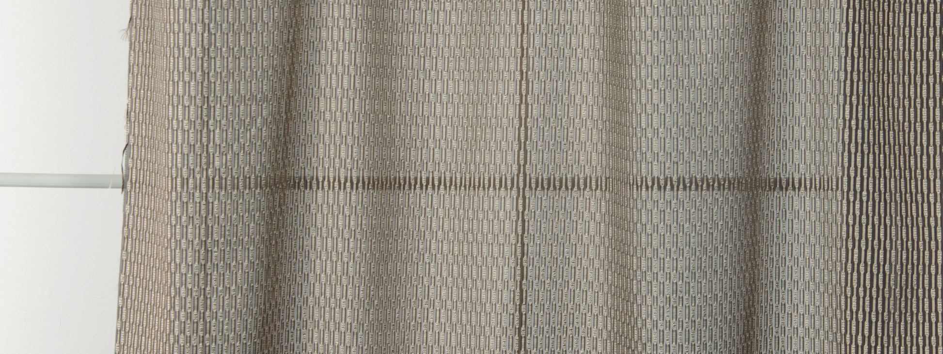 Beige woven curtain panels with a subtle geometric honeycomb pattern and soft drape.