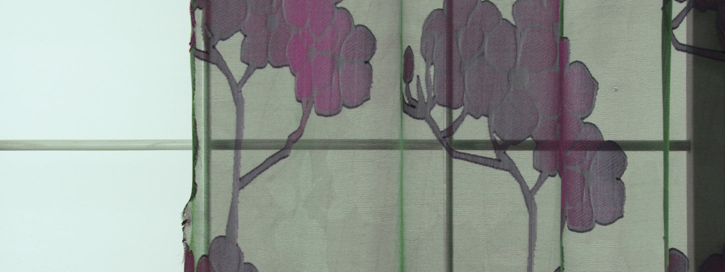 Green-tinted drapery fabric with purple tree silhouettes and a grid pattern.