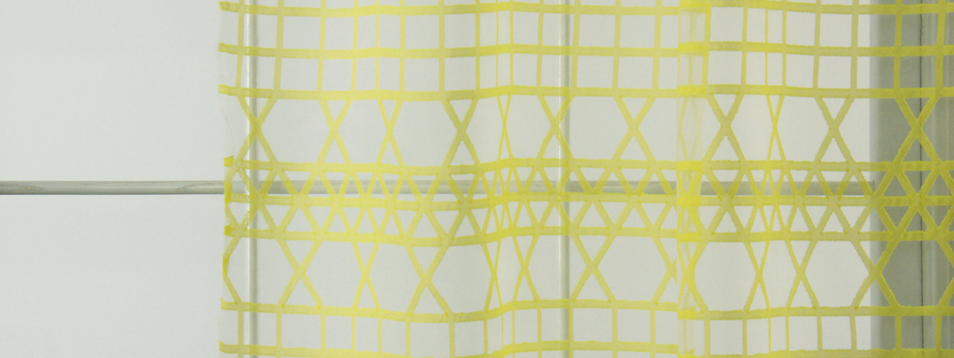 Citron triangle-grid drapery fabric with a geometric triangle pattern.