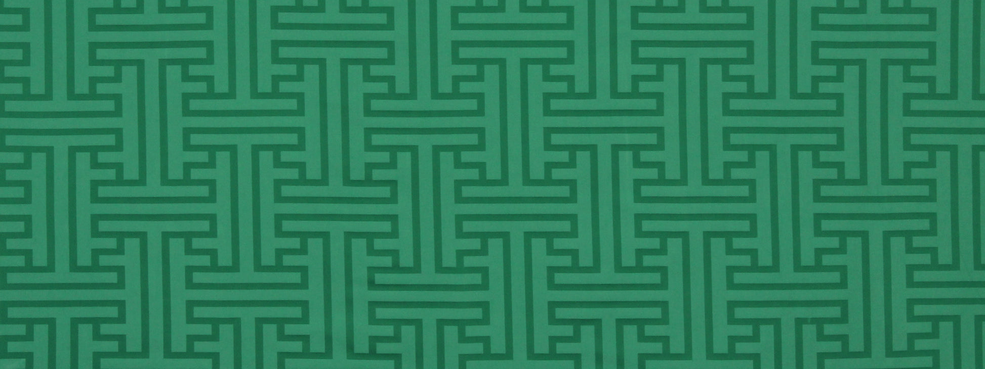 Teal-green Greek key meander geometric pattern on upholstery fabric.