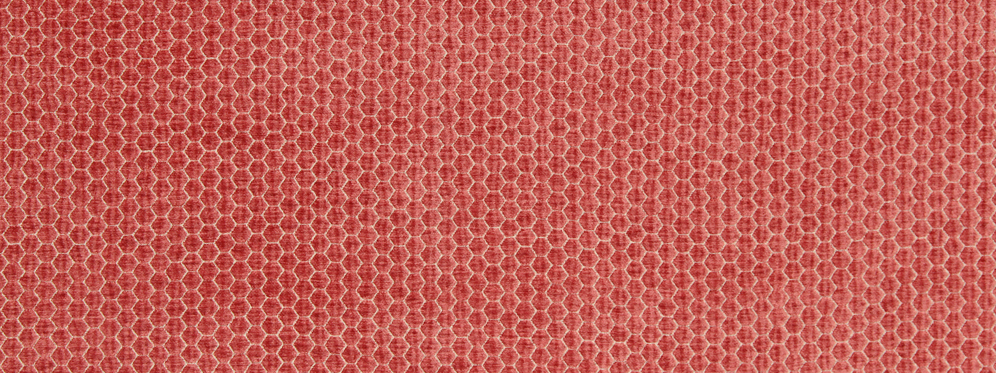 Coral upholstery fabric close-up with a honeycomb texture and mesh-like pattern.