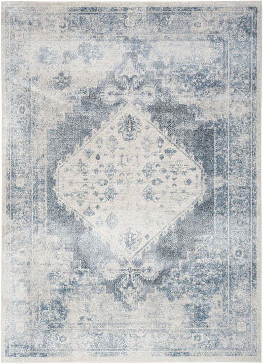 Rectangular distressed blue and ivory oriental rug with central diamond medallion and ornate border.