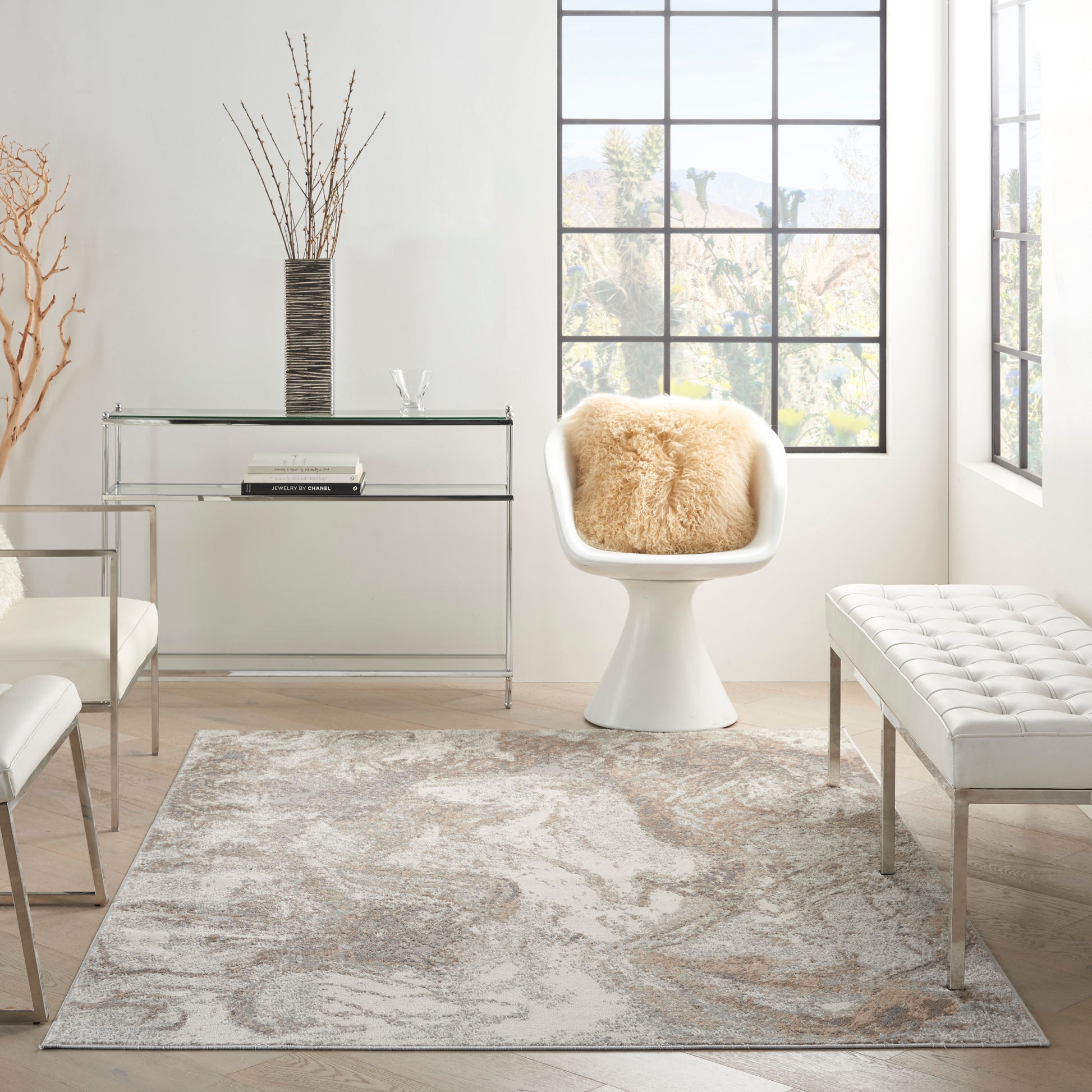 Bright modern living room with white tulip chair, sheepskin throw, glass console table, tufted bench, beige patterned rug.
