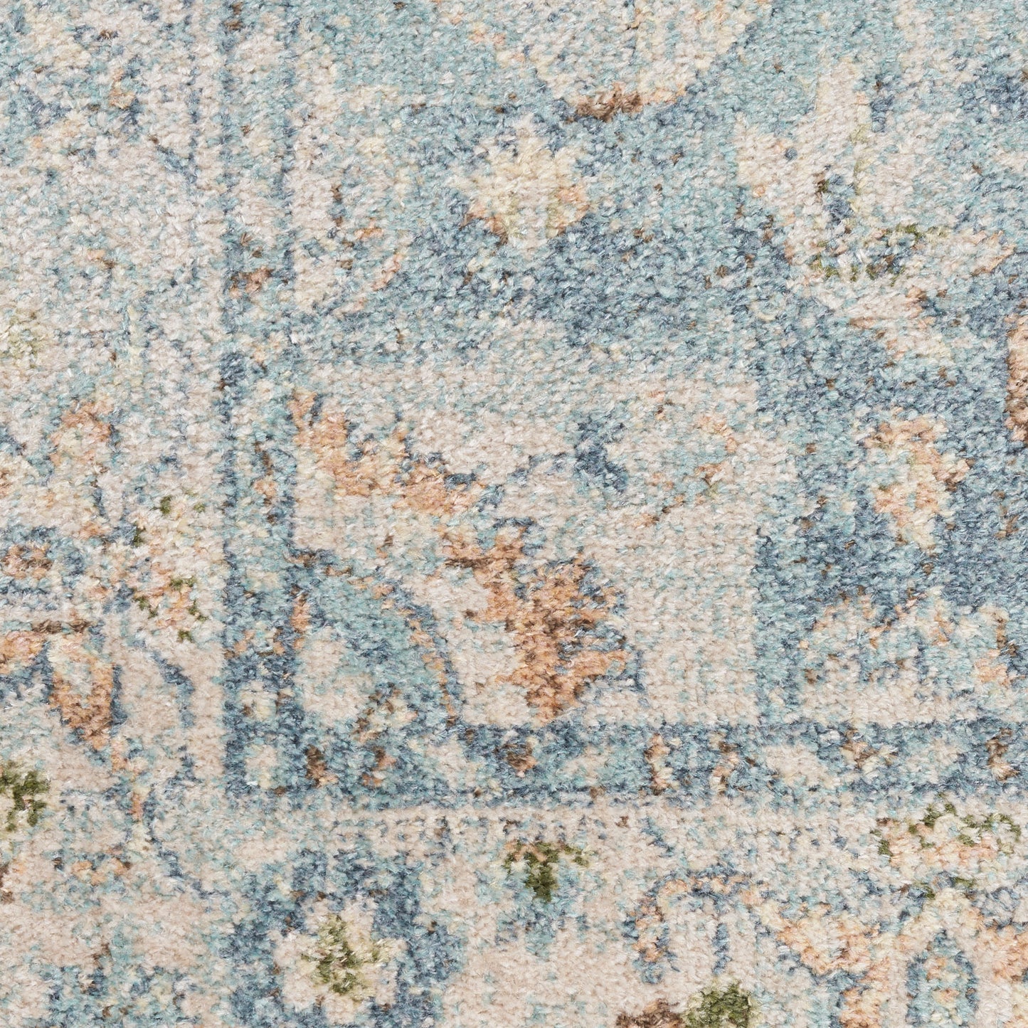 Distressed blue and ivory traditional rug close-up with beige floral motifs and subtle green accents.