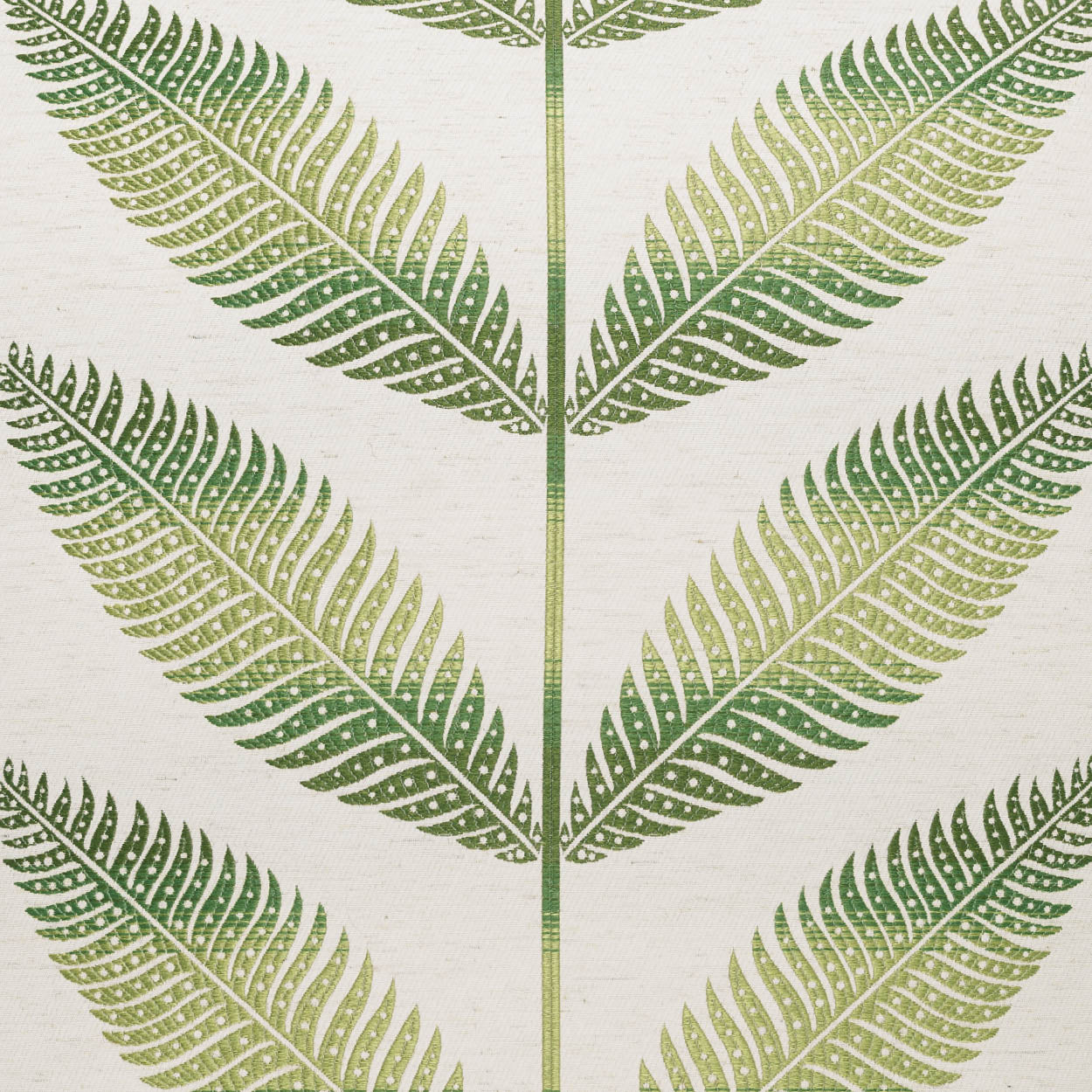 Cream pillow with a green floral motif featuring fern-like leaves and a symmetric repeating pattern.