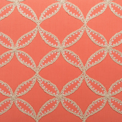 Pillow in coral fabric with cream crochet lattice of interlocking circles, edged with floral scalloped trim.