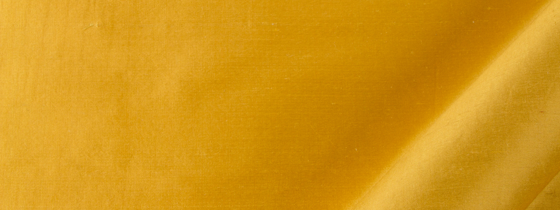 Gold silk drapery fabric with a diagonal crease and a glossy, shimmering finish.