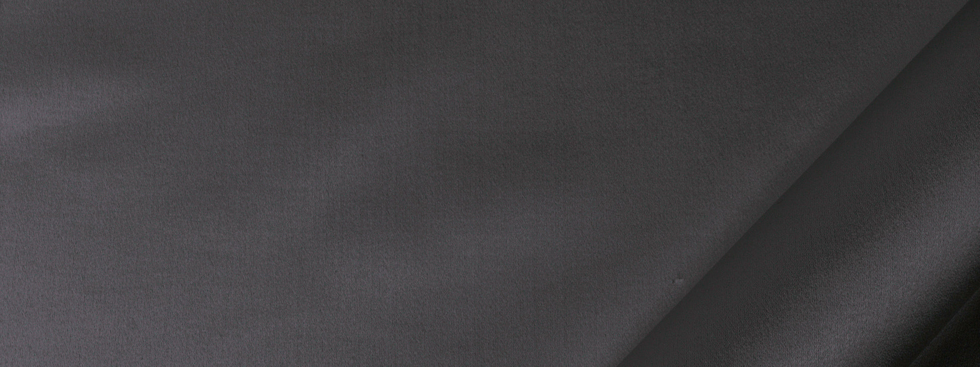 Dark gray fabric close-up with a diagonal seam, smooth matte texture suitable for drapery