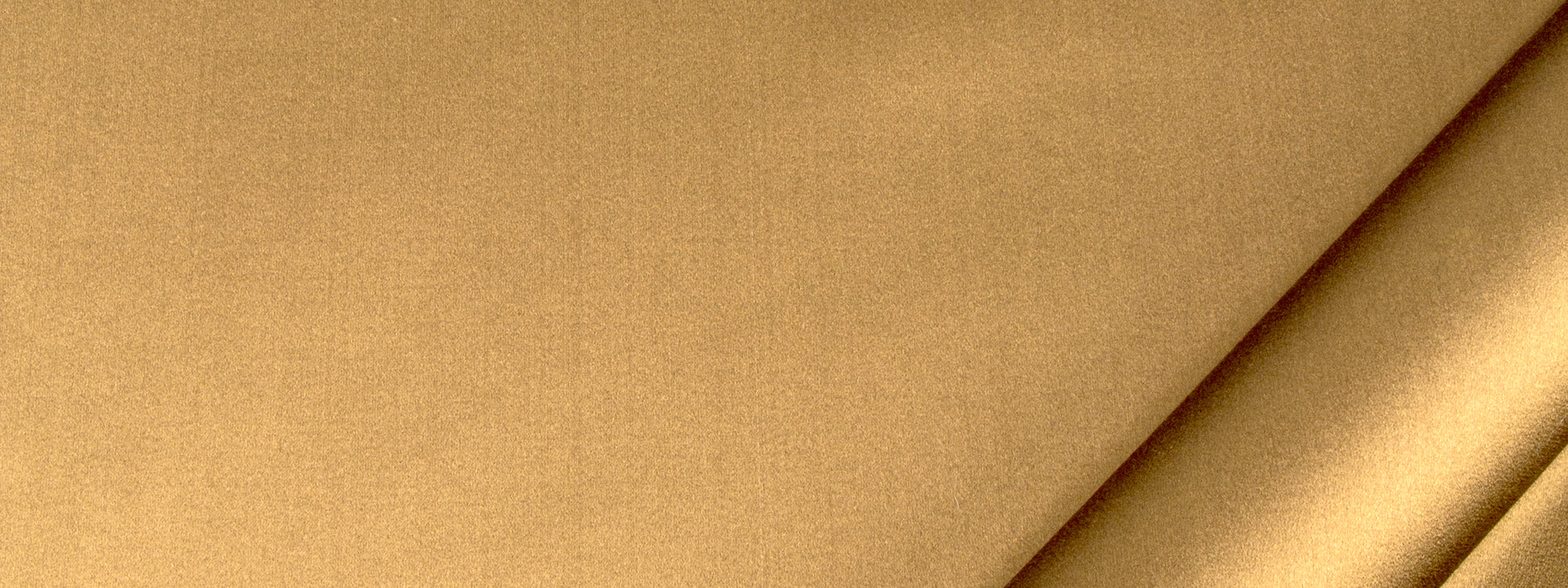 Tan beige fabric close-up with a diagonal crease and subtle woven texture.