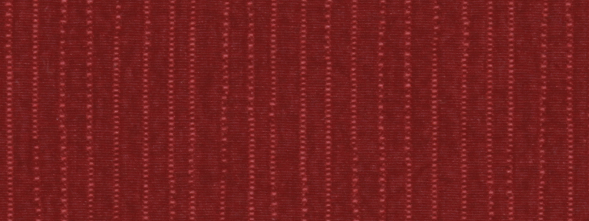 Close-up of crimson red ribbed woven fabric with narrow vertical stripes.