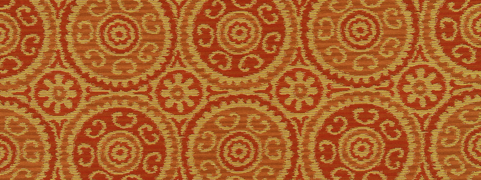 Orange and tan circular medallion pattern upholstery fabric with repeating rosette motifs.