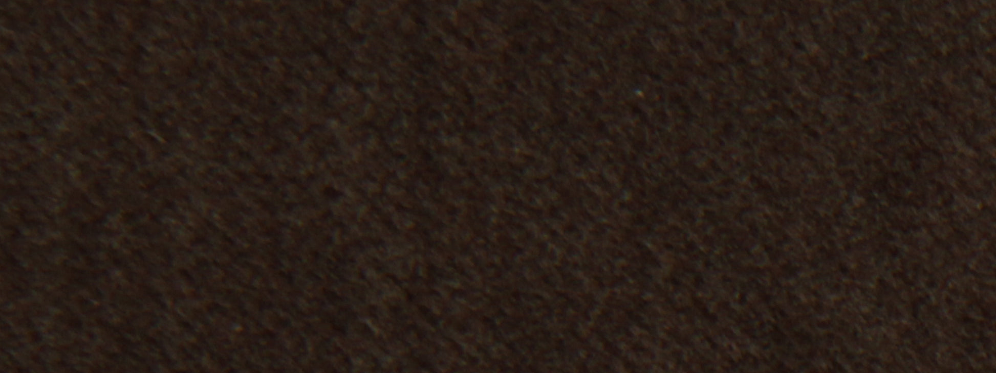 Close-up of dark brown suede-like fabric with soft nap; versatile for upholstery or apparel.