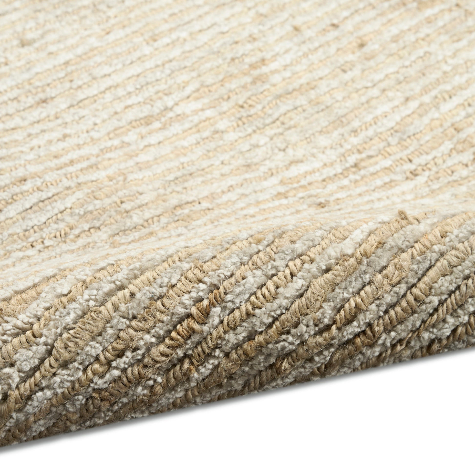 Neutral beige and cream rug with thick braided loops; textured, cozy coastal style for living room.