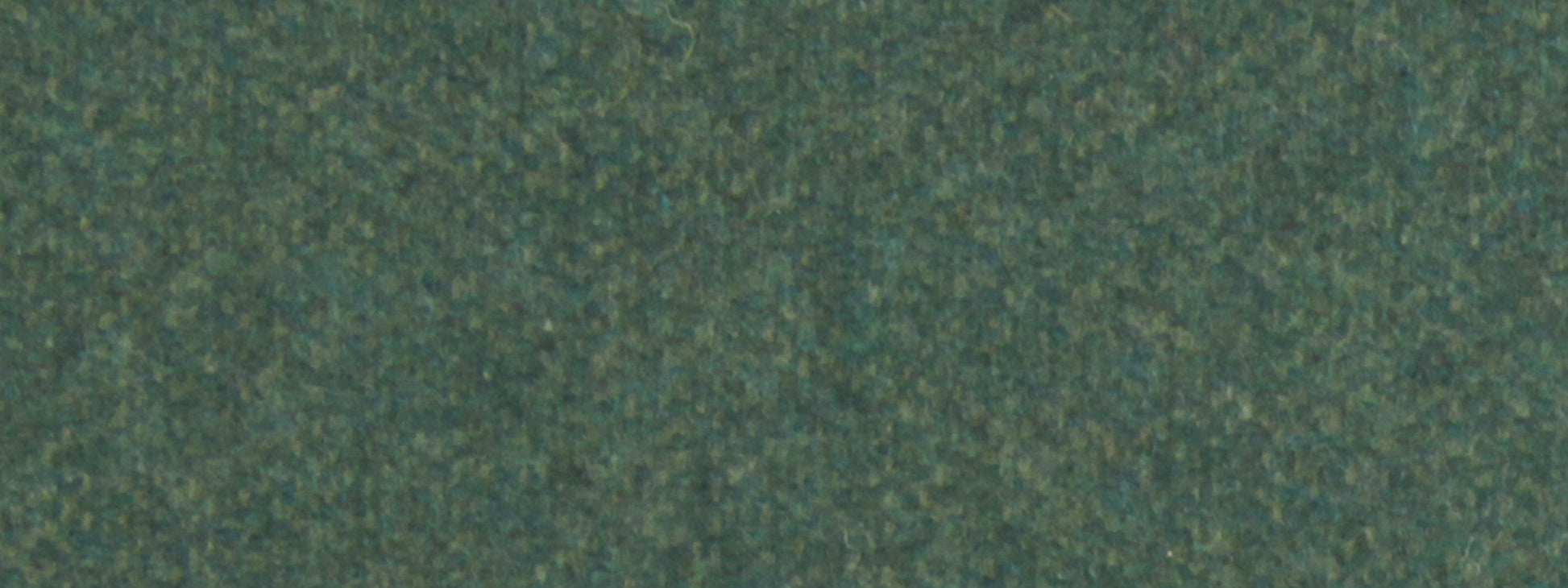Close-up of a green textured upholstery fabric surface with dark and light flecks.