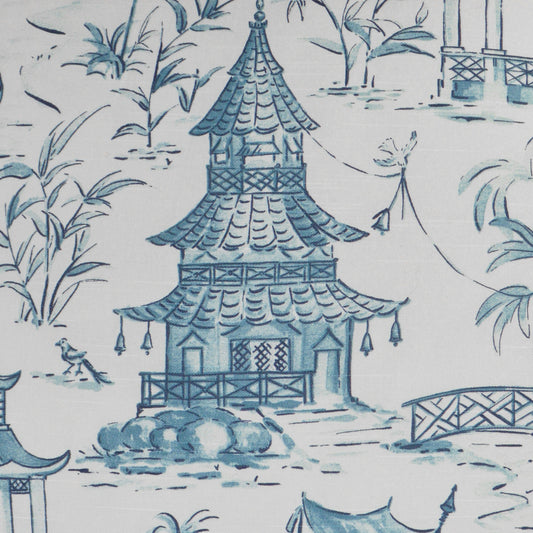 Blue pagoda temple chinoiserie pattern on white fabric with bamboo and bridge motifs.