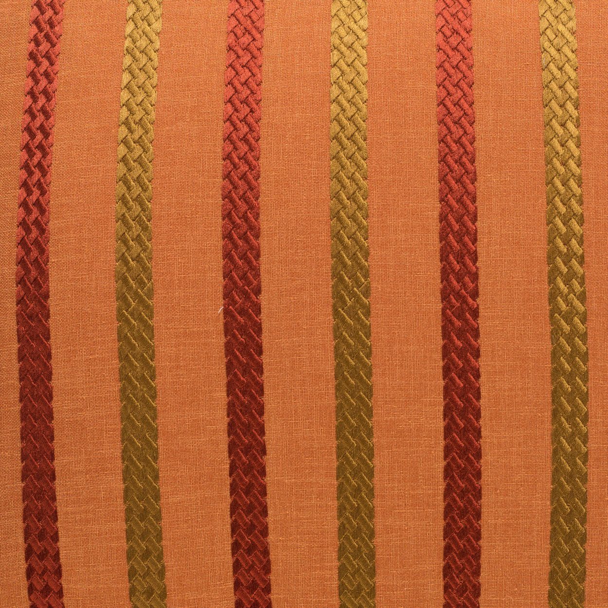 Orange fabric with vertical braided stripes in red, gold and rust tones, woven textured look on a 24 x 24 pillow