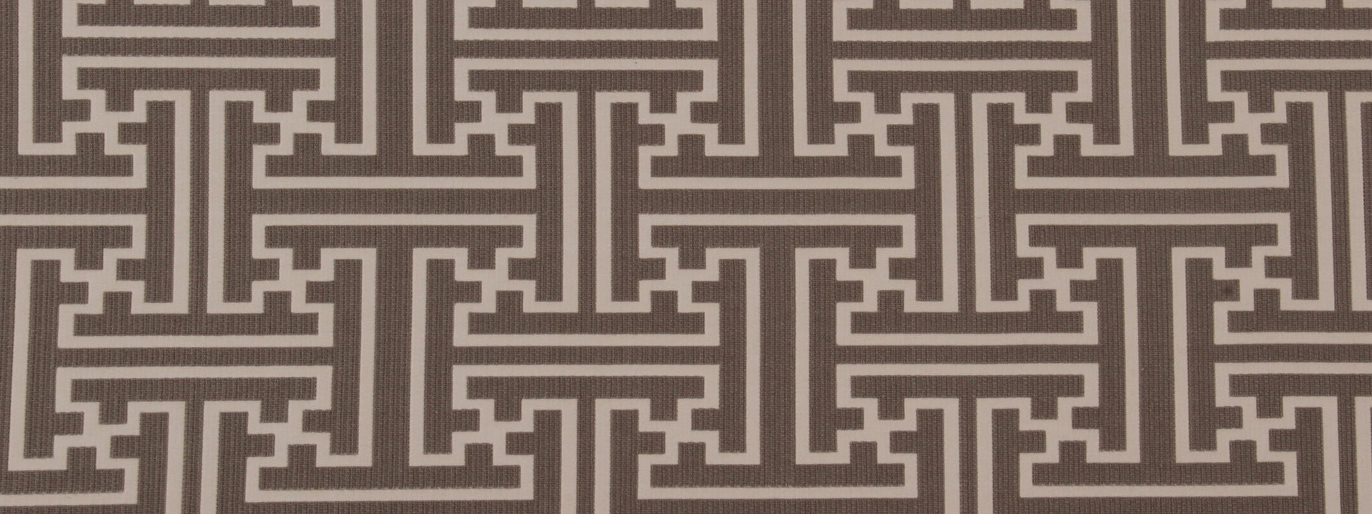 Brown textured fabric with cream Greek-key maze pattern in repeating panels.