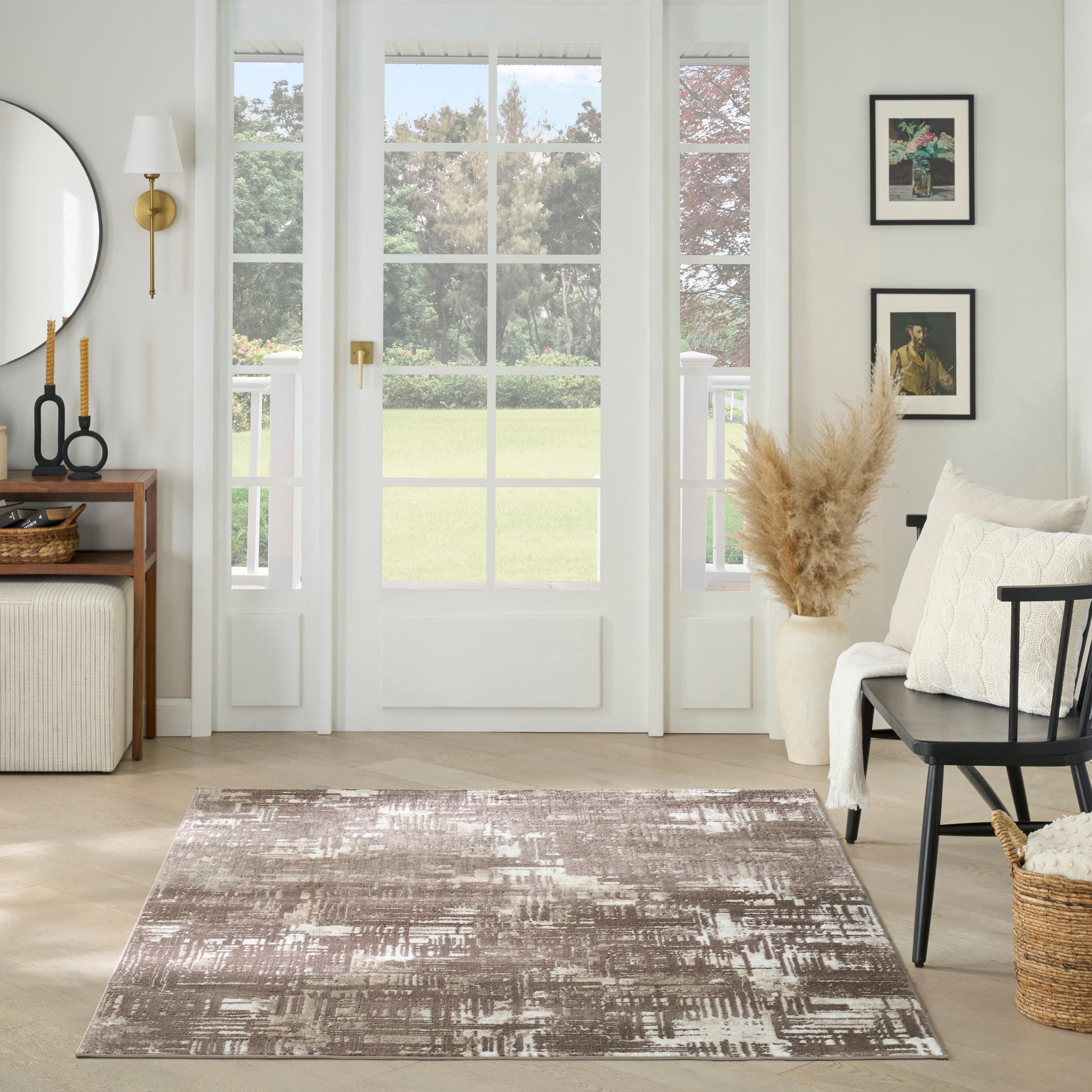 Brown and ivory abstract area rug on a light wood floor in a bright living room with minimalist decor.