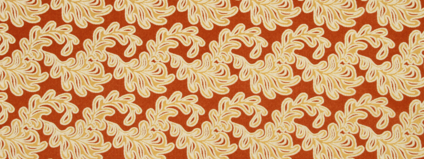 Burnt orange fabric with cream scrolling leaf motifs and a bold paisley-inspired pattern for upholstery or apparel.
