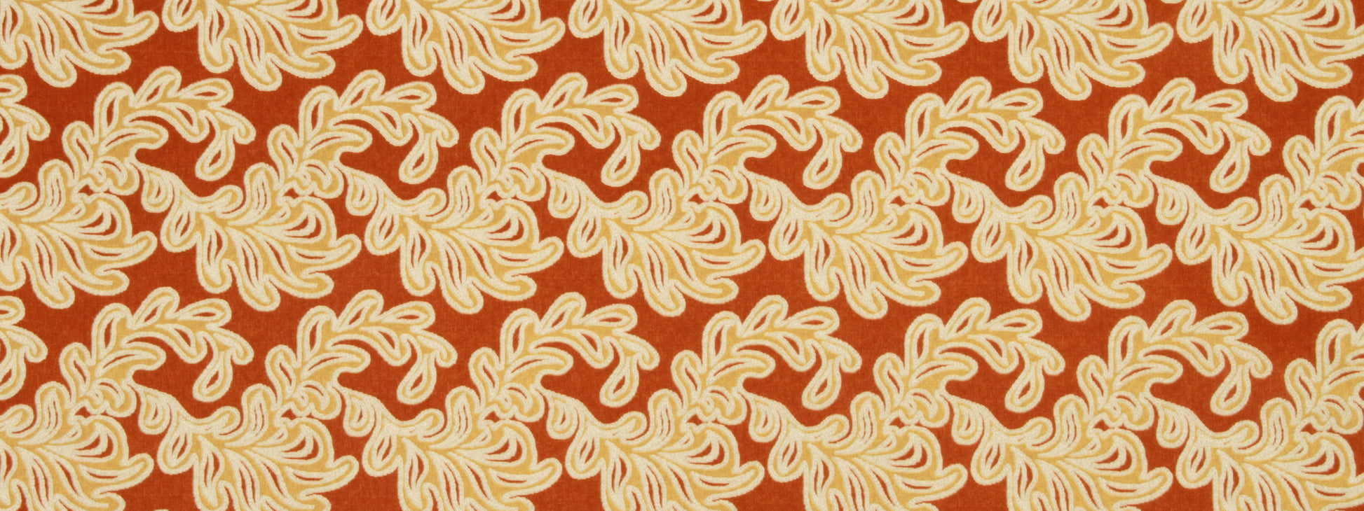 Burnt orange fabric with cream scrolling leaf motifs and a bold paisley-inspired pattern for upholstery or apparel.