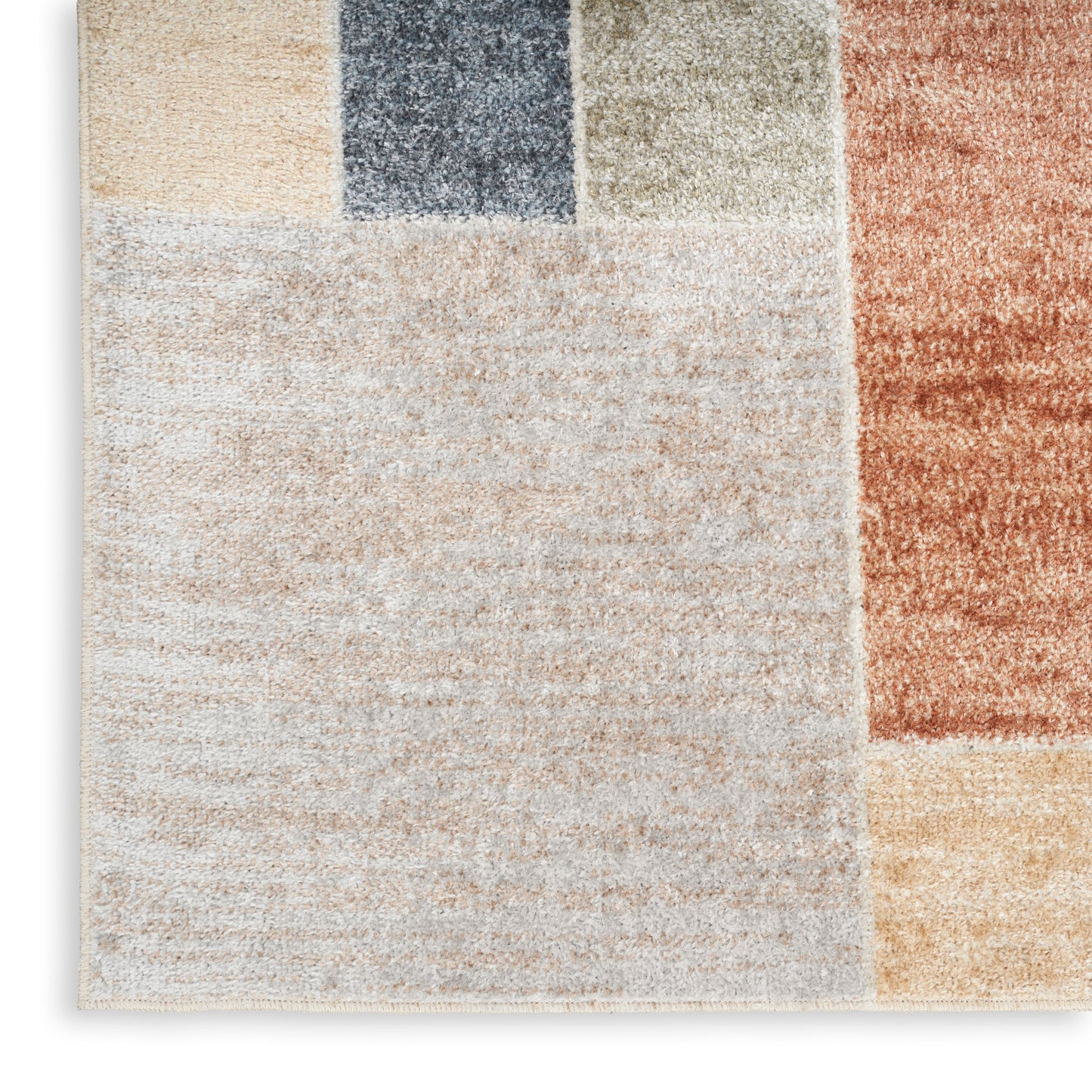 Patchwork rug with large cream block and color blocks in navy, gray, tan, rust & mustard; plush, modern geometric style.