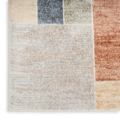 Patchwork rug with large cream block and color blocks in navy, gray, tan, rust & mustard; plush, modern geometric style.
