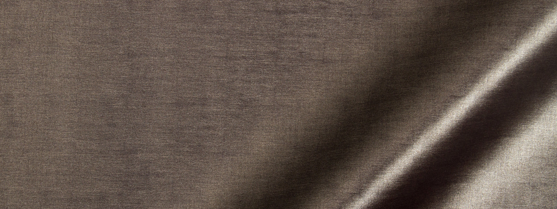 Close-up of brown linen-like fabric with a diagonal light highlight and subtle weave.