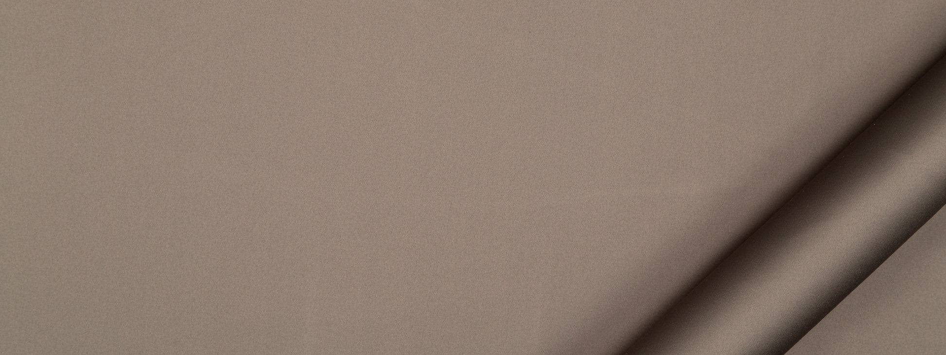 Taupe suede-like fabric close-up with rolled edge at bottom-right.