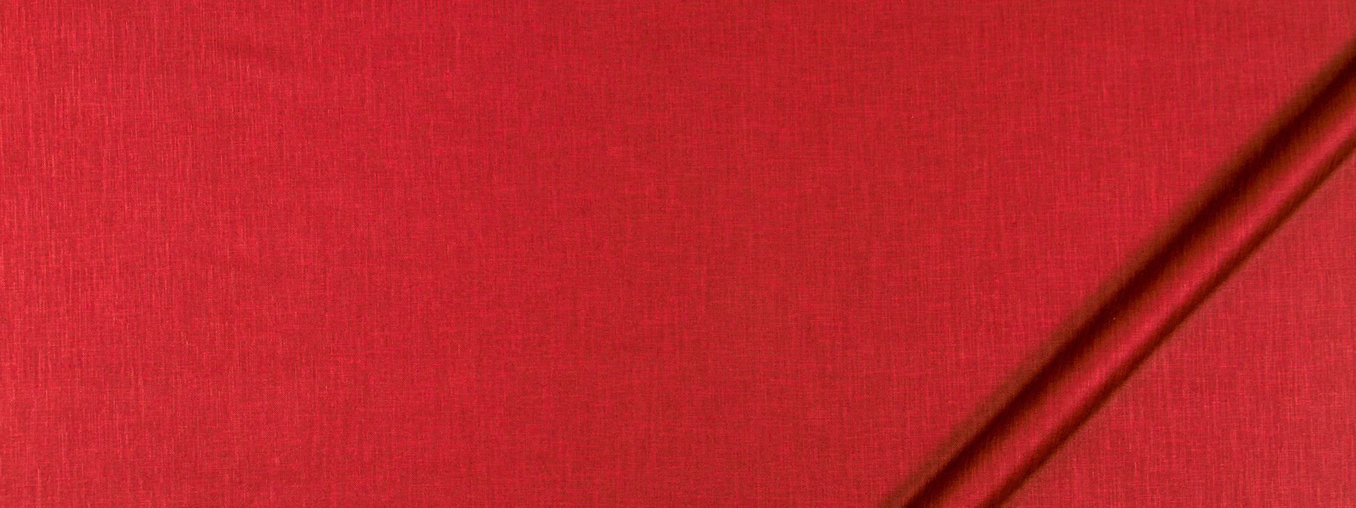 Bright red fabric texture with a slim brown rod diagonally across the top-right corner.