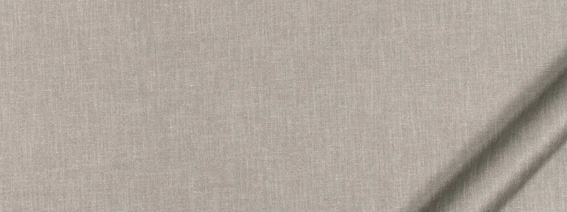 Beige linen fabric close-up with woven texture and diagonal light shadows.