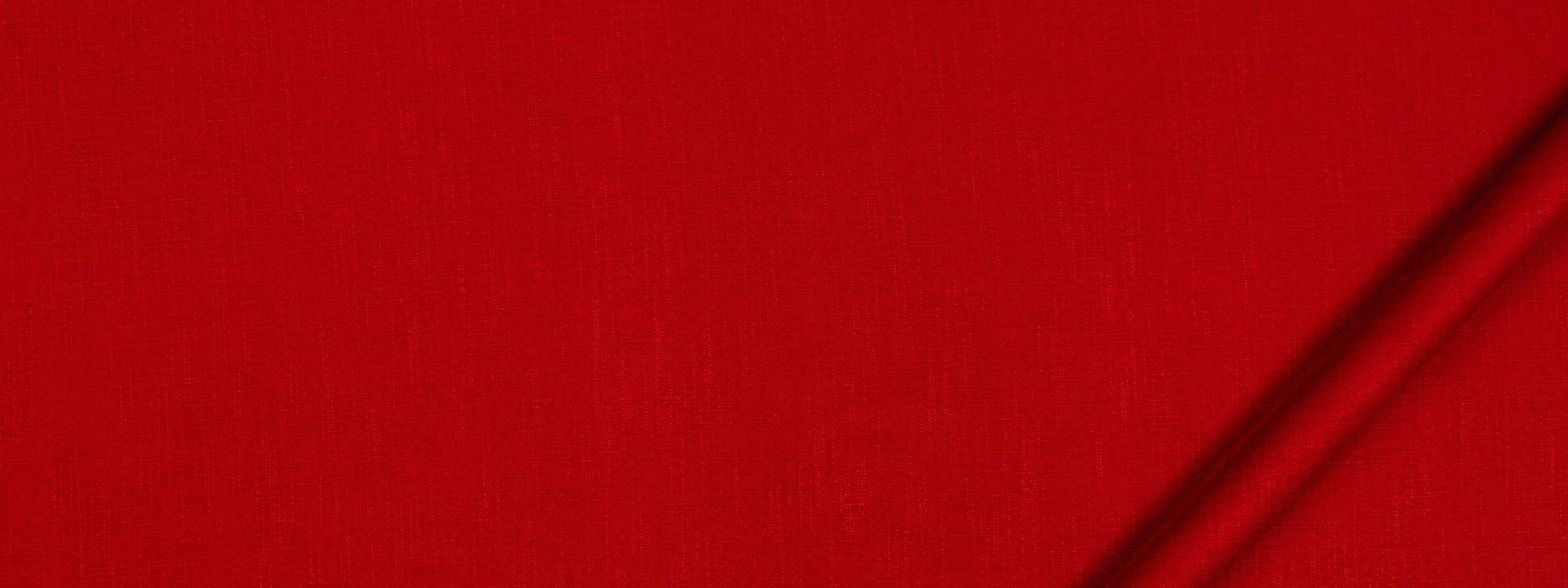 Close-up of bright red fabric with a dark diagonal seam along the edge; bold minimalist textile.