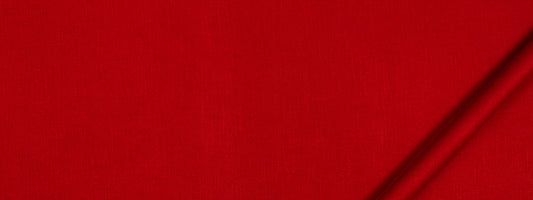 Close-up of bright red fabric with a dark diagonal seam along the edge; bold minimalist textile.