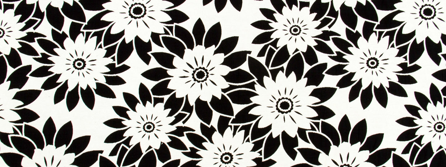 Bold black-and-white floral print with large daisy-like blooms, high-contrast graphic fabric pattern.