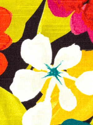 Bright tropical floral fabric with large white hibiscus petals, blue stamen, yellow and black background, pink/orange accents