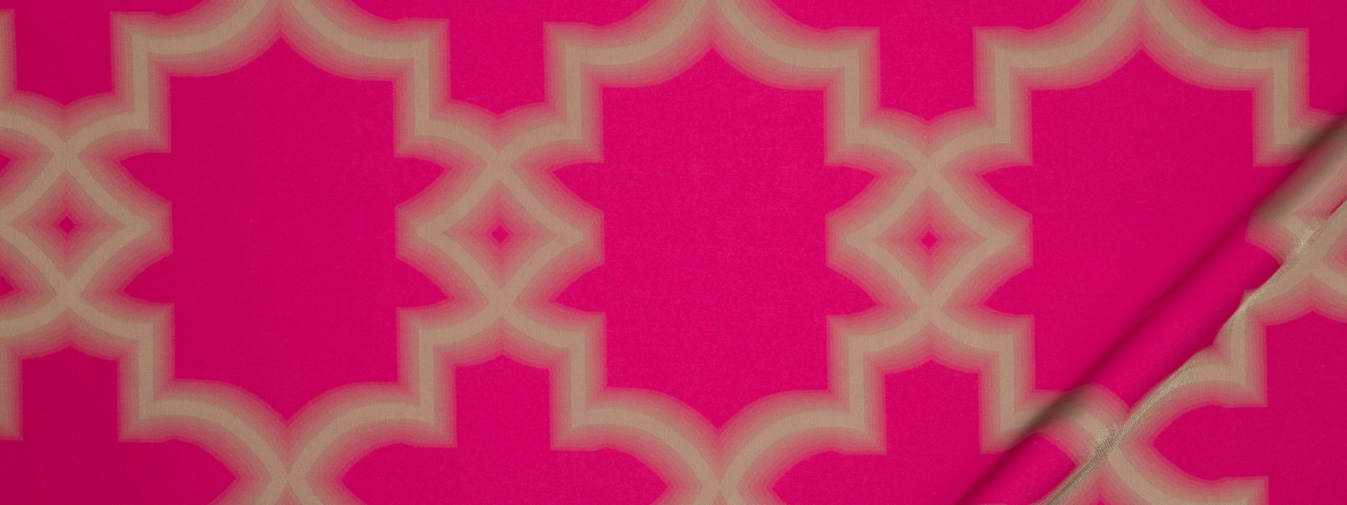 Bright pink fabric with cream interlocking quatrefoil lattice pattern; bold Moroccan-inspired textile.