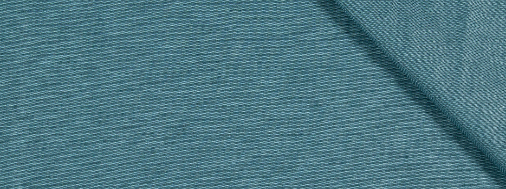 Blue-teal upholstery fabric with visible texture and a diagonal crease/shadow across the upper-right area.