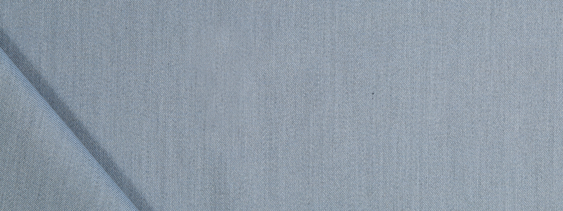 Close-up of light blue fabric with a subtle woven texture and a soft, denim-like appearance.