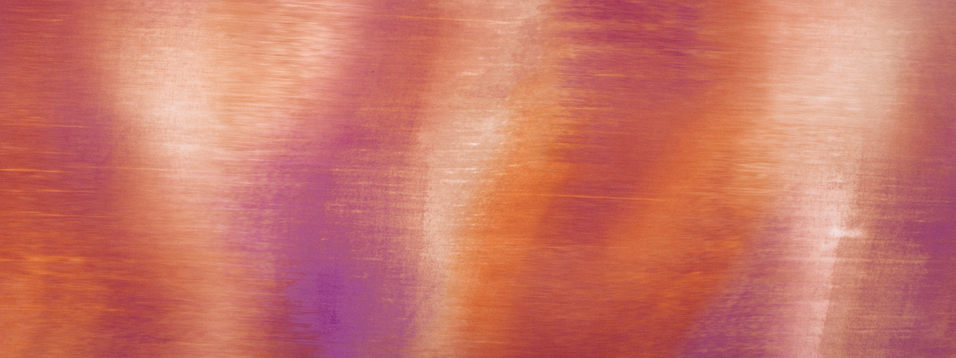 Brushed metallic surface in warm orange-copper and purple tones; abstract texture for decor or backdrop.