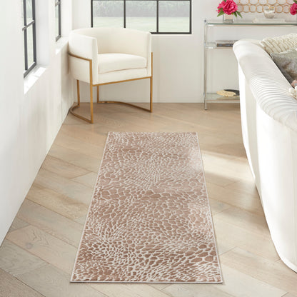 Beige animal-pattern long runner rug on light wood floor beside white modern sofa and cream armchair.