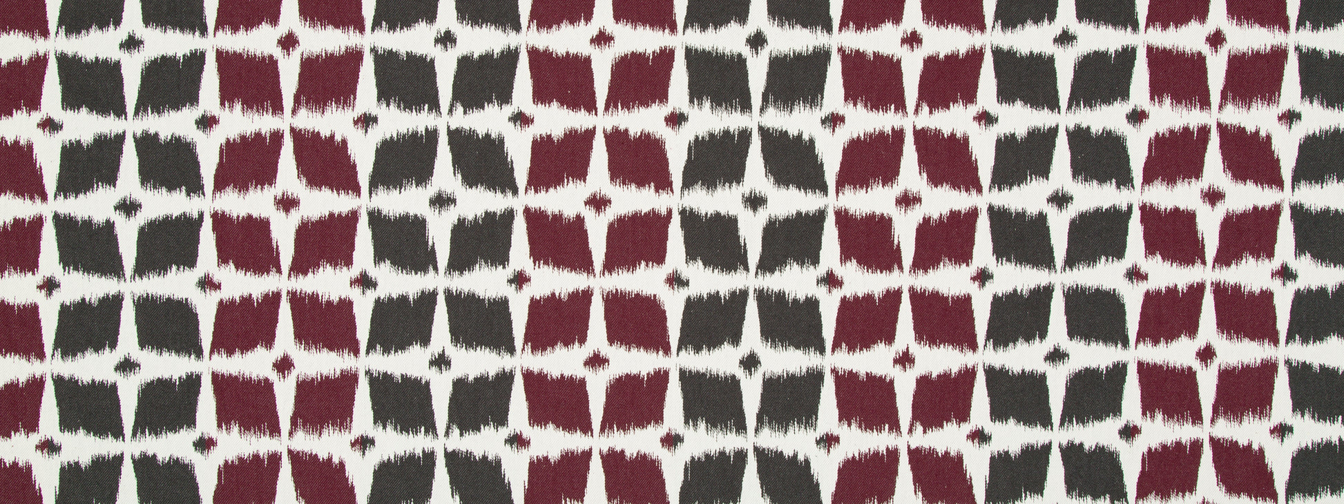 Textile featuring a repeating burgundy and charcoal quatrefoil grid on ivory background.