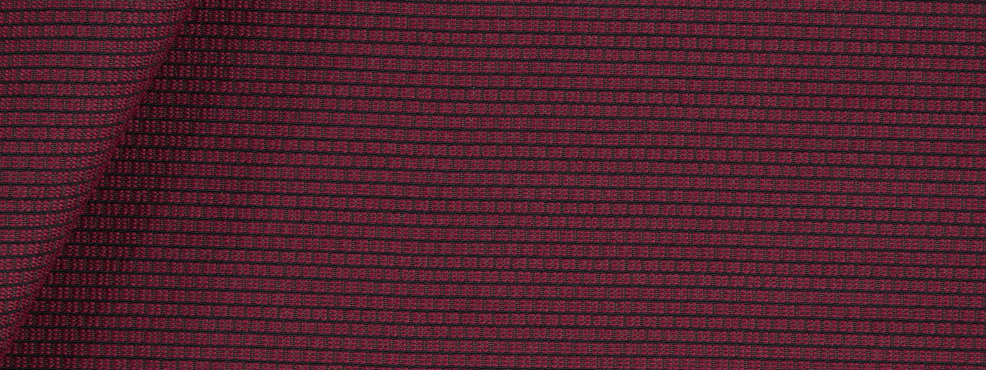 Maroon woven fabric with a tiny grid checker pattern and subtle texture, lightly folded at the top-left.