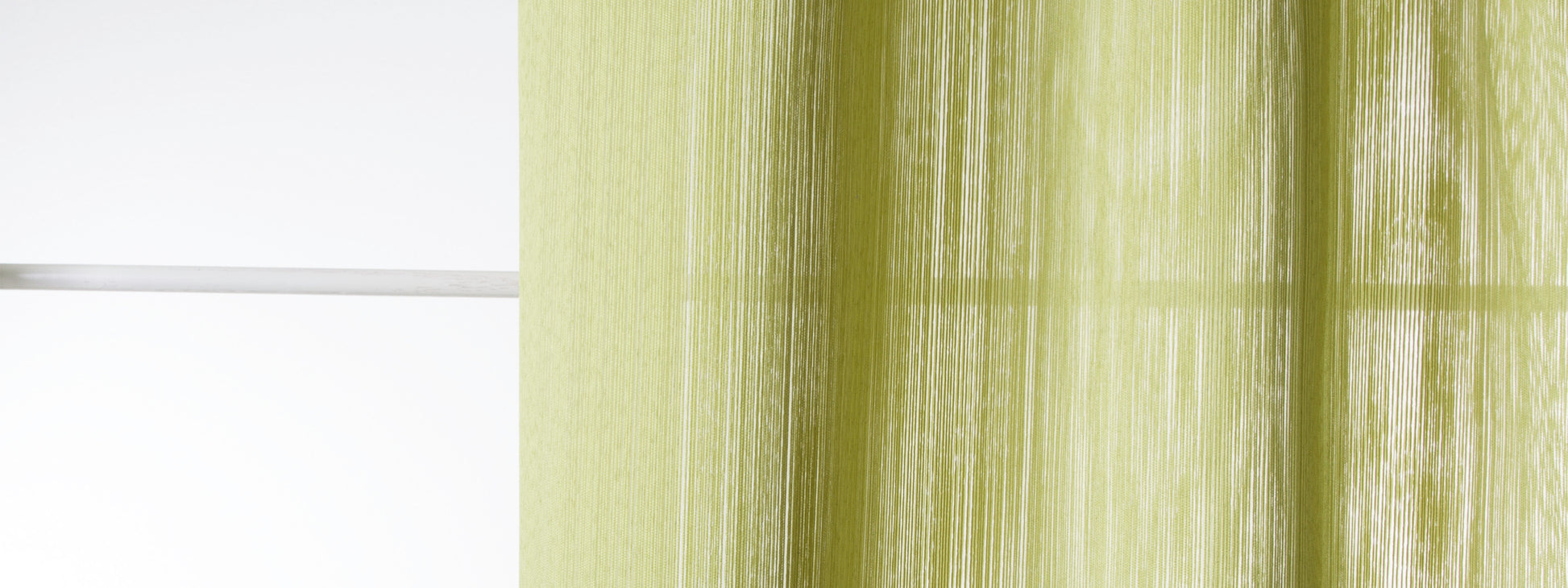 Lime-green sheer curtain with vertical folds beside a white window frame.