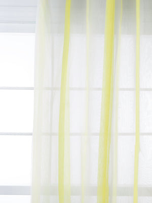 Sheer citrine net curtains with pale yellow vertical stripes, diffusing light through the window.